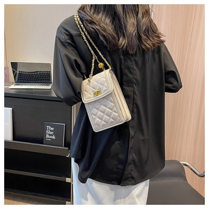 Chic cream quilted mini crossbody bag with gold chain strap shown on a shoulder