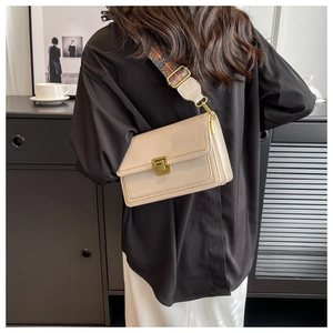 Sac bandoulière blanc cassé avec sangle ethnique colorée porté par un mannequin