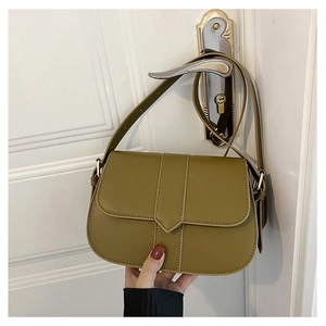 Detailansicht einer olivgrünen Satteltasche aus Leder mit goldfarbenen Metallteilen