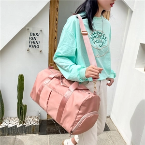 Pink large capacity travel bag with dry-wet separation and shoe compartment worn by model