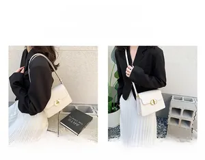 Détail d'un sac carré en cuir crème montrant les modes porté épaule et bandoulière