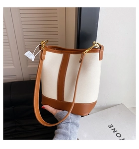 Close-up of contrast color bucket bag with lychee grain texture and metal hook detail