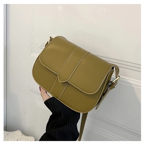 Nahaufnahme der olivgrünen Satteltasche mit Lederriemen und goldenen Metallteilen