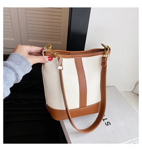 Detail of contrast color bucket bag showing stitching and gold-tone hardware