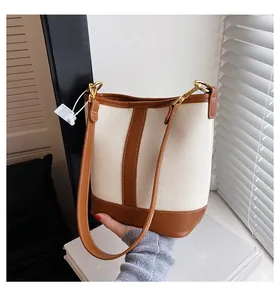 Detail of vintage bucket bag featuring off-white pebble grain and brown leather stitching