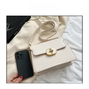 Comparaison de taille d'un sac à bandoulière beige minimaliste avec un fermoir doré et mobile