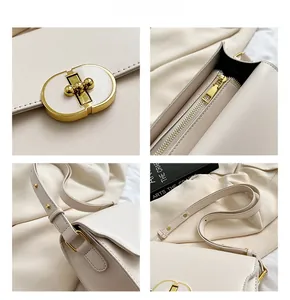 Détail du sac bandoulière en cuir crème avec fermoir doré ovale et couture nette