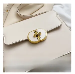 Vue détaillée du sac à main en cuir beige avec fermoir métallique doré élégant