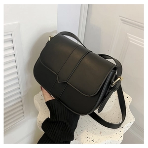Detailansicht einer schwarzen Vintage-Satteltasche mit Goldbeschlägen und Lederstruktur
