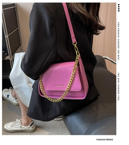 Detail view of pink lavender shoulder bag with lychee grain texture and metal chain strap