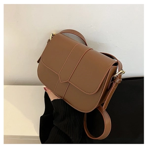Details der karamellbraunen Satteltasche mit mattem Leder und goldener Metallschnalle