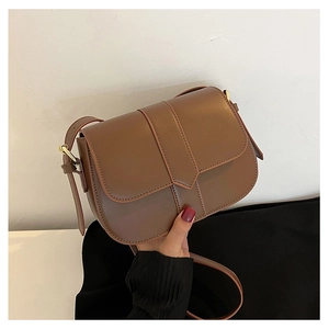 Detailansicht einer braunen Satteltasche aus Leder mit Riemen und goldener Metallschnalle
