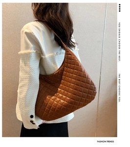 Brown quilted tote bag shown on model's shoulder for large capacity visual reference