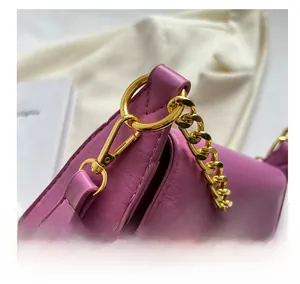 Detail of purple crossbody bag featuring lychee texture leather and golden metal chain