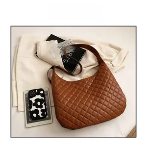 Detailed view of a brown quilted hobo bag with glossy finish and elegant texture
