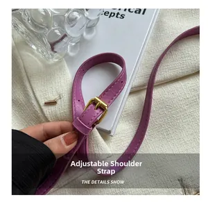 Detail of adjustable purple leather shoulder strap with gold metal buckle and texture