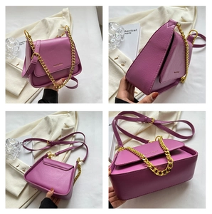 Close-up of fuchsia square crossbody bag with gold chain and refined leather texture