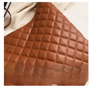 Detail shot of brown quilted leather texture and premium stitching on a shoulder bag