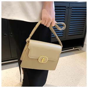 Détail du petit sac bandoulière beige avec une boucle métallique dorée élégante