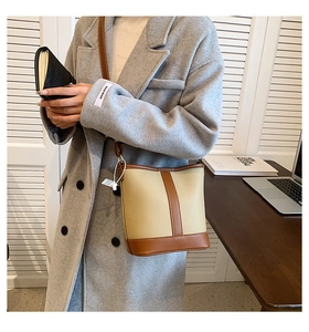 Detail of vintage bucket bag featuring beige lychee leather and dark brown stitching