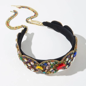 Close-up of luxury baroque headband with multi-color crystals and long gold tassel chains