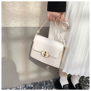 Gros plan du sac en cuir crème avec boucle ovale dorée et bandoulière réglable