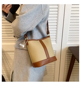Detail of two-tone bucket bag featuring beige pebble leather and brown contrast trim