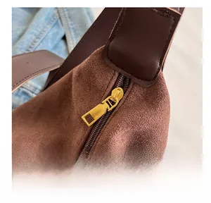 Macro detail of high-quality smooth golden zipper and brown matte suede texture