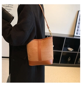 Detail of brown patchwork bucket bag with suede texture and smooth leather trim