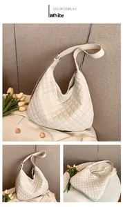Detail of white quilted leather texture and adjustable wide strap on shoulder bag
