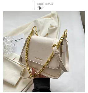 Detail of off-white leather shoulder bag featuring gold chain and flap closure