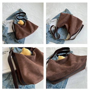 Detail of dark brown matte suede tote bag with leather straps and bear charm