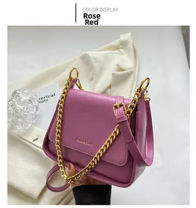Detail of rose red crossbody bag with chunky gold chain and Muon & Shark logo hardware