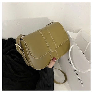 Detailansicht einer olivgrünen Satteltasche mit Steppnähten und goldener Schnalle