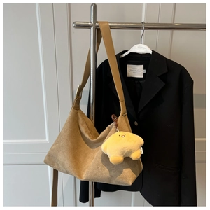 Close-up of khaki matte suede tote bag featuring a star plush charm on a metal hanger