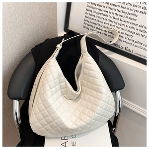 Detailed view of white quilted shoulder bag with spacious interior and soft leather texture