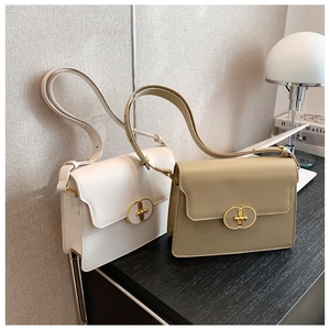 Détail de sacs bandoulière en cuir beige et kaki avec boucles dorées ovales élégantes