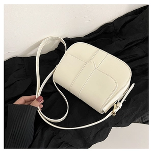 Detailansicht der cremeweißen Satteltasche mit Ziernähten und goldenen Schnallen