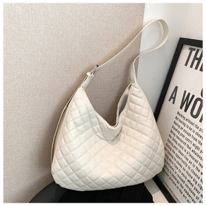 Close-up of a white quilted hobo bag featuring detailed diamond stitching and texture