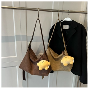 Detail of matte tote bags in coffee and khaki colors with star plush keychains