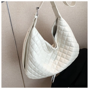 Detailed macro view of quilted diamond pattern and smooth PU leather of the tote bag