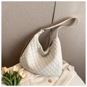 Detail of off-white quilted hobo bag with adjustable strap and smooth silver hardware