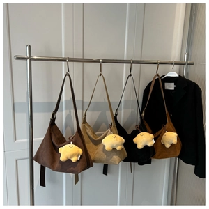 Hanging display of four suede tote bags in earthy tones with star-shaped plush pendants