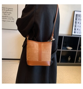 Detail of vintage brown bucket bag showing contrast texture and leather vertical strip