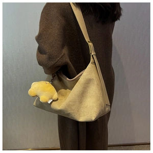 Brown frosted suede shoulder bag shown as a crossbody tote on model's shoulder