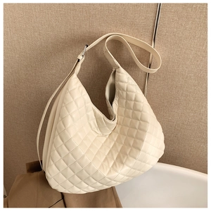 Macro shot of quilted pattern texture on cream white hobo shoulder bag for women