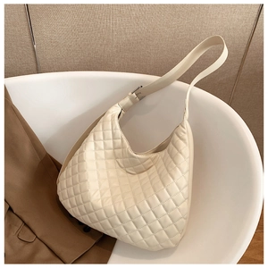 Detail of cream beige quilted hobo bag with adjustable strap in a stylish setup