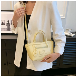 Sac bandoulière jaune pâle avec poche avant zippée décorative et étiquette de mode