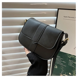 Detailaufnahme einer schwarzen Leder-Satteltasche mit Klappverschluss und Riemen