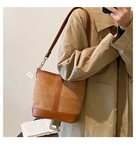 Detail of vintage bucket bag featuring brown suede and smooth leather stitching detail